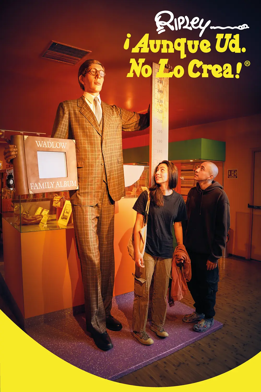 Pareja junto a réplica de cera de la persona más alta del mundo